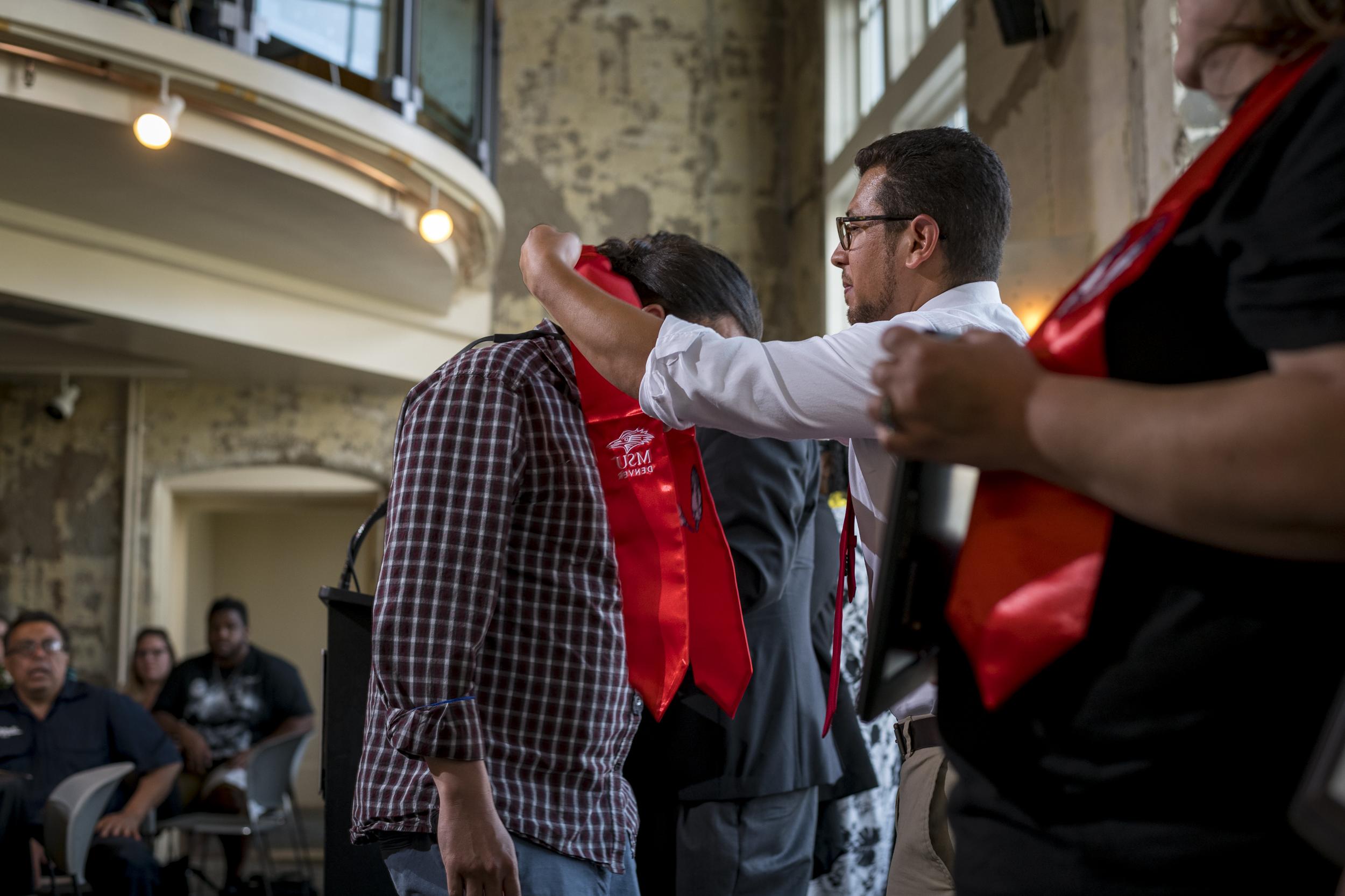 A man bestowing a stole onto a graduate